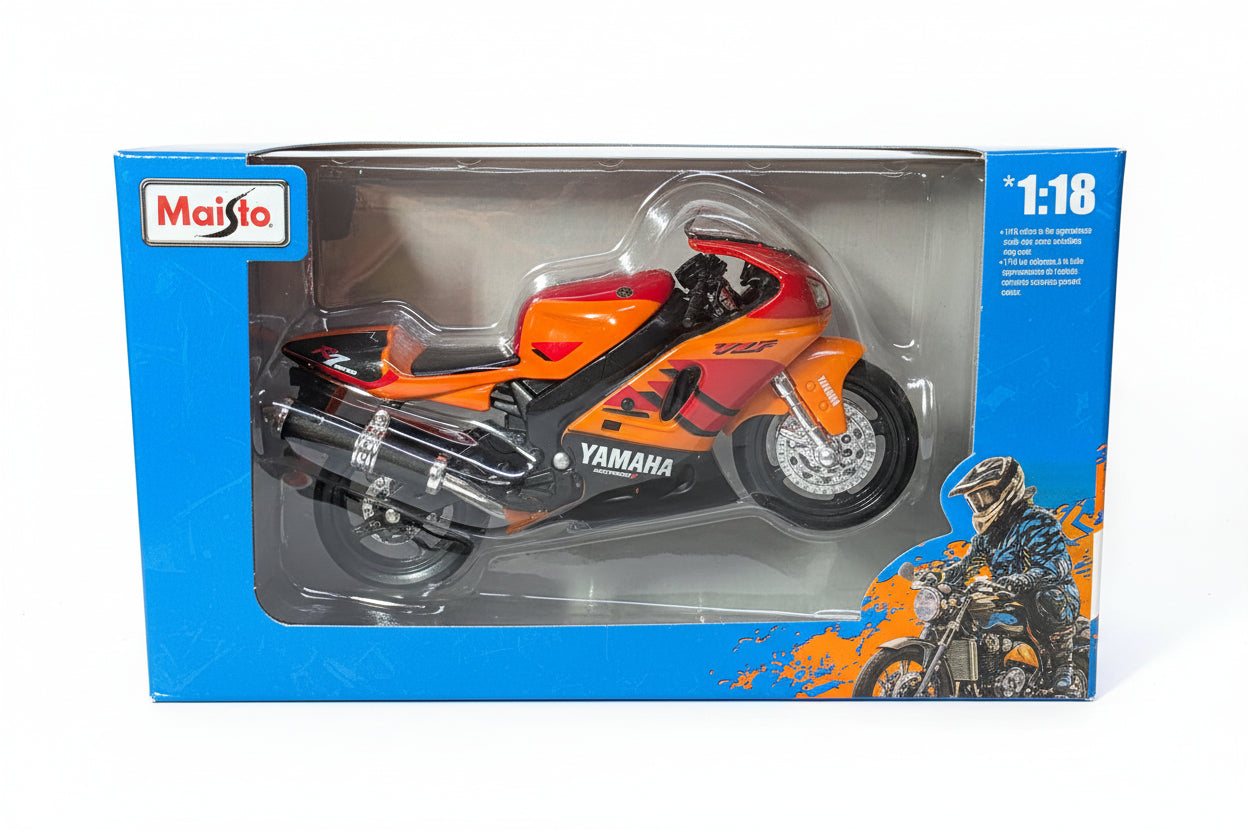 A 1:18 scale model of a Yamaha sport motorcycle in orange, red, and black, displayed inside its blue and clear plastic Suiso brand retail box.