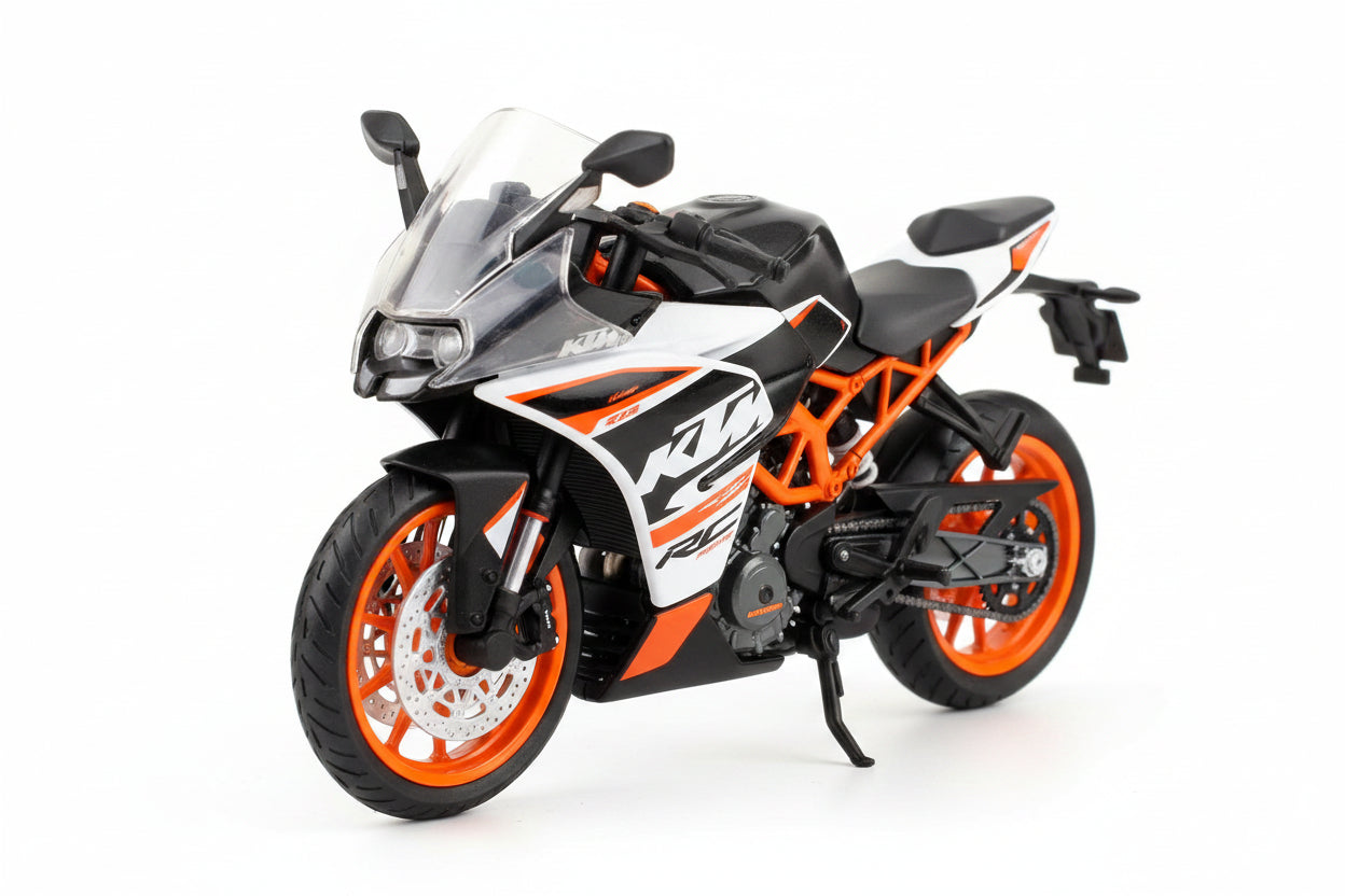 A toy die-cast motorcycle in its original blister packaging, featuring a white and orange KTM sportbike design with black wheels.